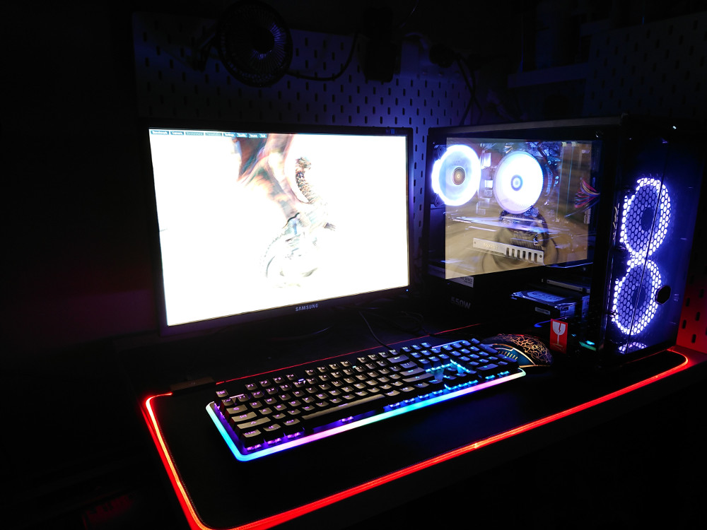 Auf einem Schreibtisch steht ein beleuchtetes Gaming-Setup