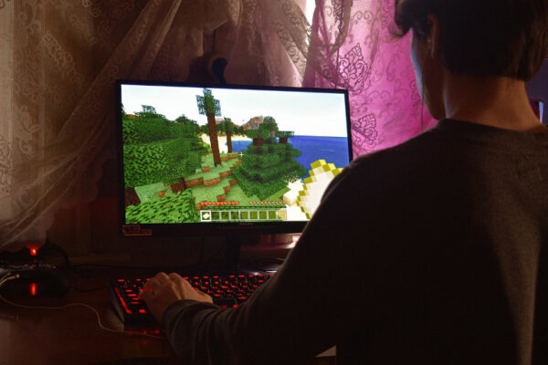 Ein Mann spielt an einem PC Minecraft