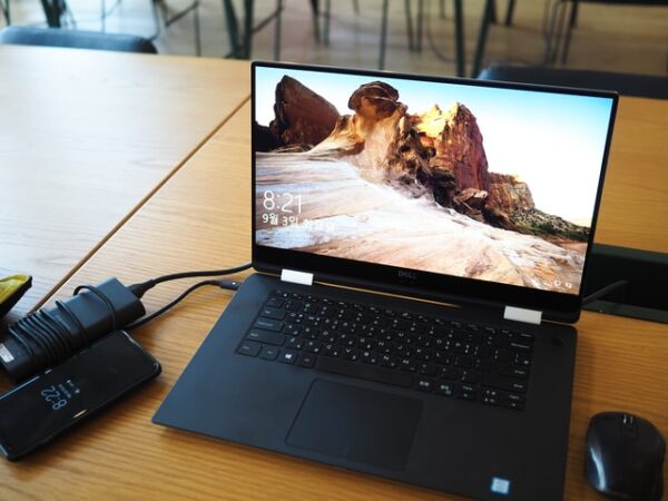 Auf einem Schreibtisch steht ein Laptop an dem ein Aufnahmegerät, ein Smartphone und eine Maus angeschlossen sind