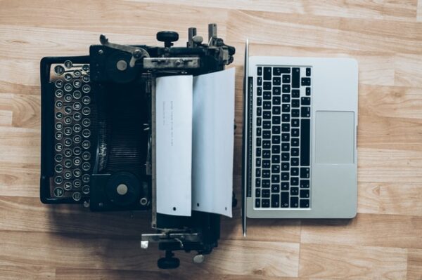 Eine Schreibmaschine und ein Laptop stehen sich gegenüber