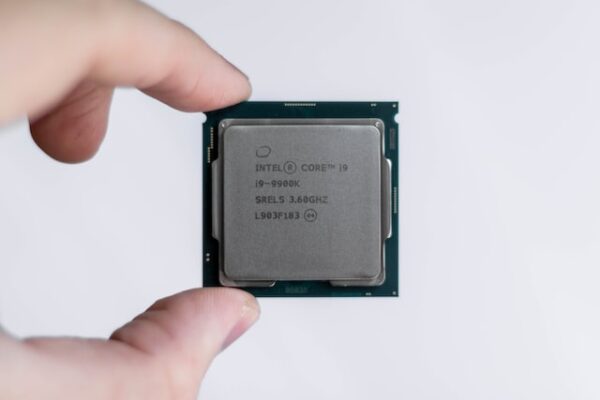 Eine Person hält eine CPU mit der Beschriftung Intel Core i9 zwischen Daumen und Zeigefinger